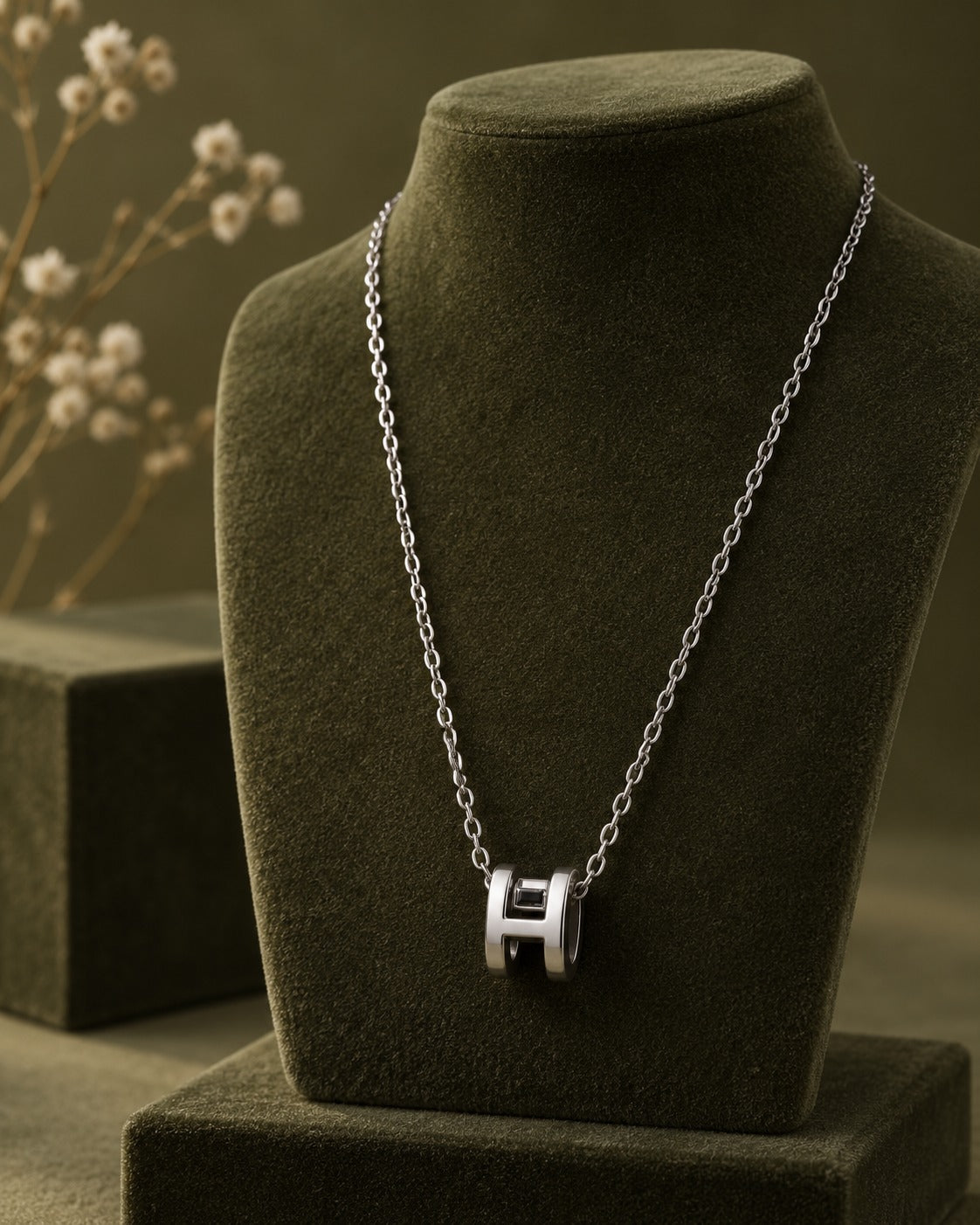 Silver-tone H-link pendant necklace styled on black slate